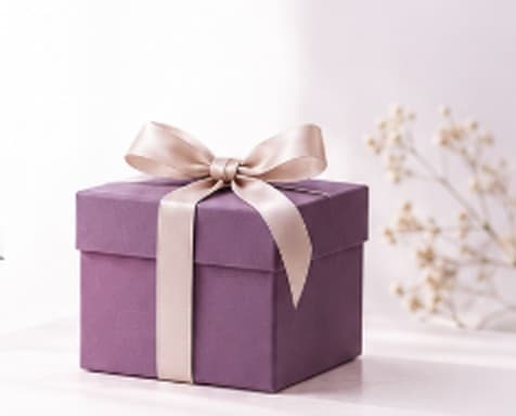 Hộp quà tím thắt nơ lụa bên cành hoa baby